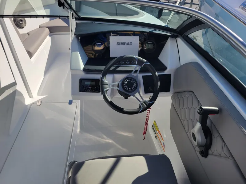 Slide: The Image of 2024 Four Winns H1 OB boat cockpit with steering wheel and Simrad display. - 14