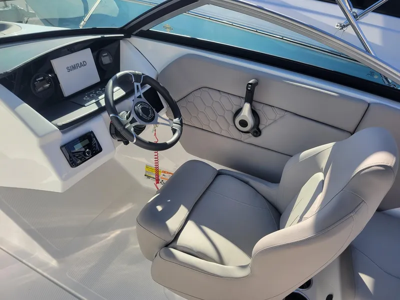 Slide: The Image of 2024 Four Winns H1 OB boat cockpit with steering wheel and Simrad display. - 15