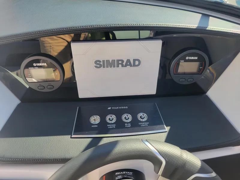 Slide: The Image of 2024 Four Winns H1 OB boat dashboard with Simrad display and Yamaha gauges. - 24