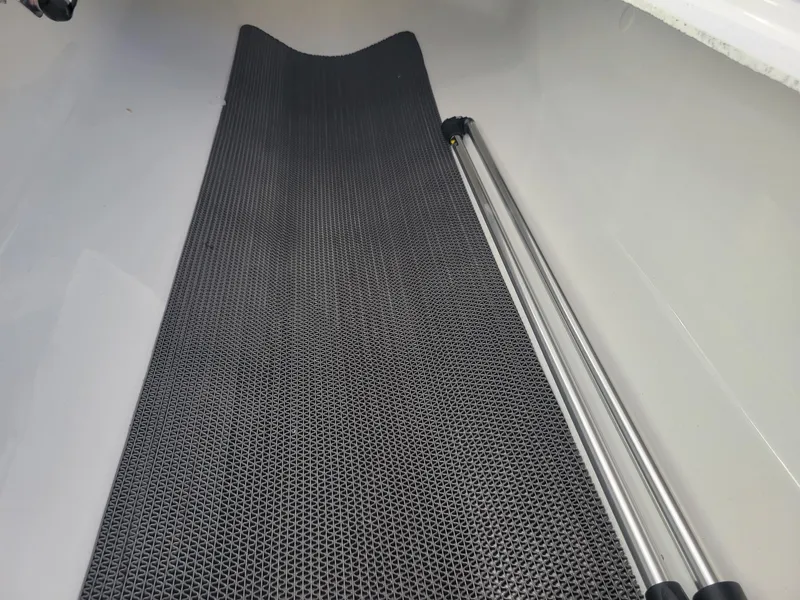 Slide: The Image of 2024 Four Winns H1 OB boat interior with black non-slip mat and metal poles. - 27