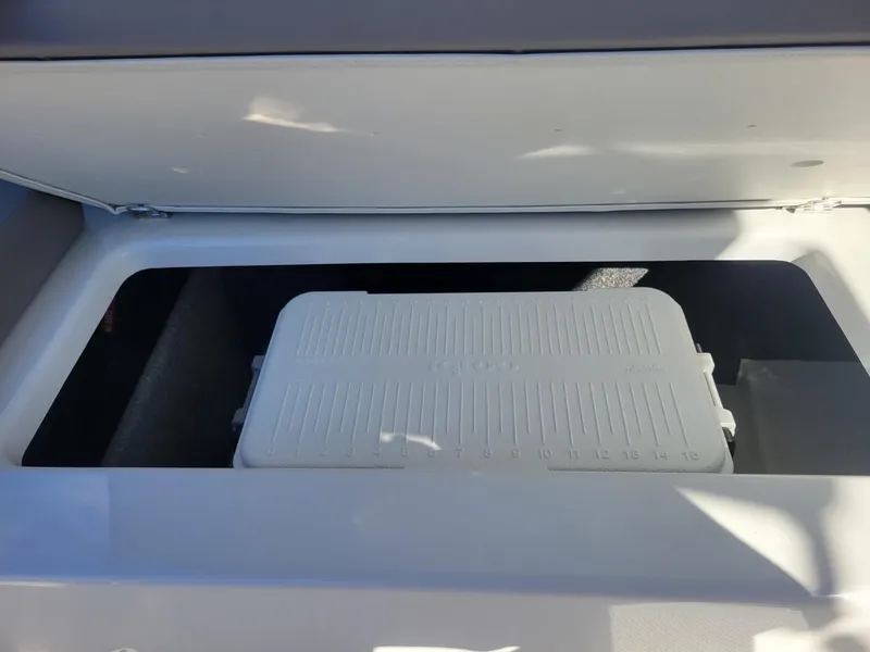 Slide: The Image of Storage compartment of 2024 Four Winns H1 OB boat with a white cooler inside. - 33