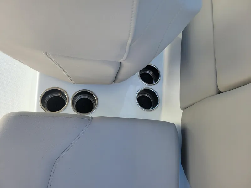 Slide: The Image of 2024 Four Winns H1 OB boat interior with cup holders and cushioned seats. - 46