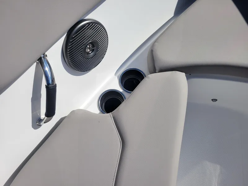 Slide: The Image of 2024 Four Winns H1 OB boat interior with cup holders and speaker. - 48