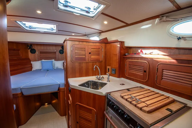 Slide: The Image of 2005 Hinckley Talaria 40 boat interior with blue seating and polished wood finish. - 19