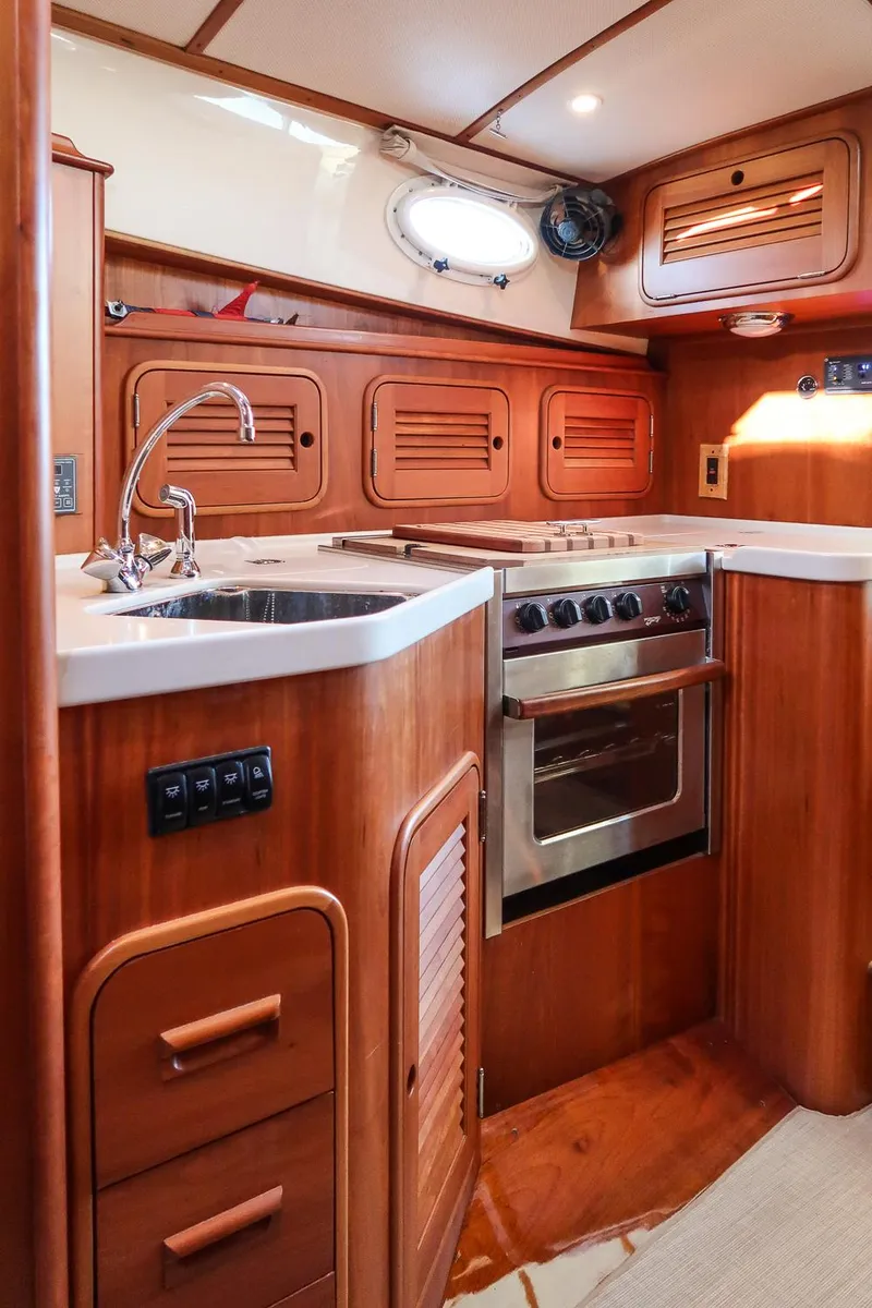 Slide: The Image of 2005 Hinckley Talaria 40 yacht interior with wooden cabinetry and modern kitchen amenities. - 21