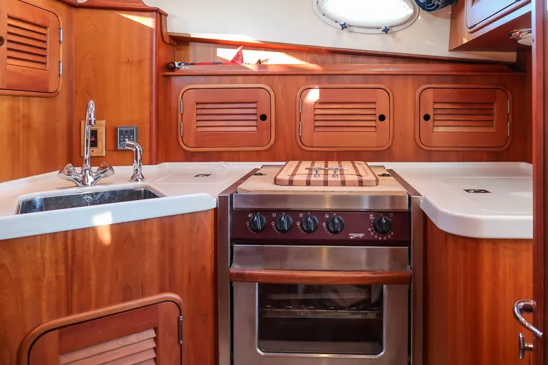 Slide: The Image of 2005 Hinckley Talaria 40 yacht kitchen with wood cabinetry and stainless steel appliances. - 23