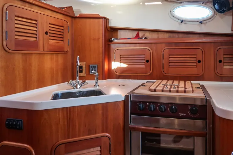 Slide: The Image of Hinckley Talaria 40 yacht kitchen interior with wooden cabinetry and stainless steel appliances, 2005 model. - 24
