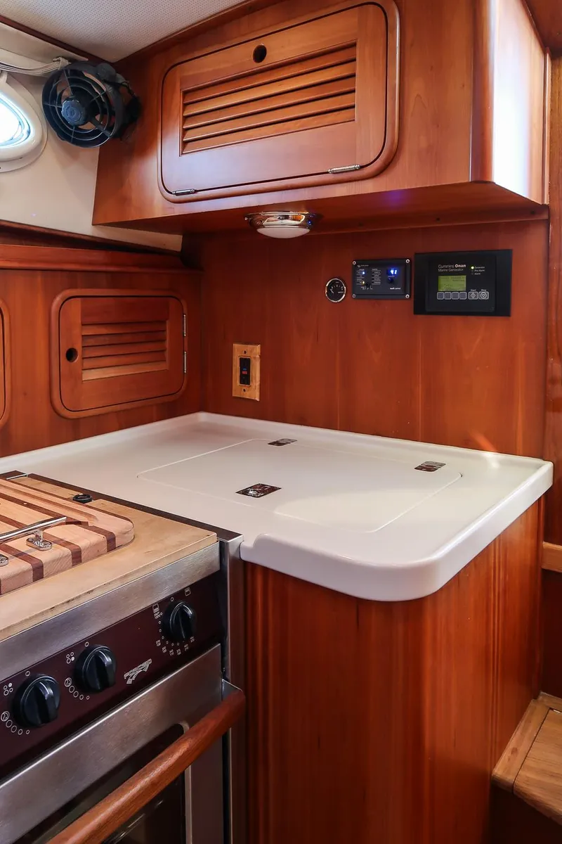 Slide: The Image of 2005 Hinckley Talaria 40 yacht interior with wooden cabinetry and modern appliances. - 26