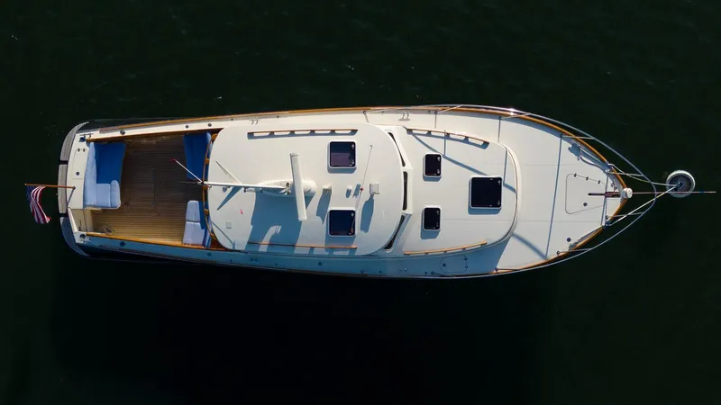 Slide: The Image of 2005 Hinckley Talaria 40 yacht kitchen with wood cabinetry, stainless steel sink, and stove. - 3