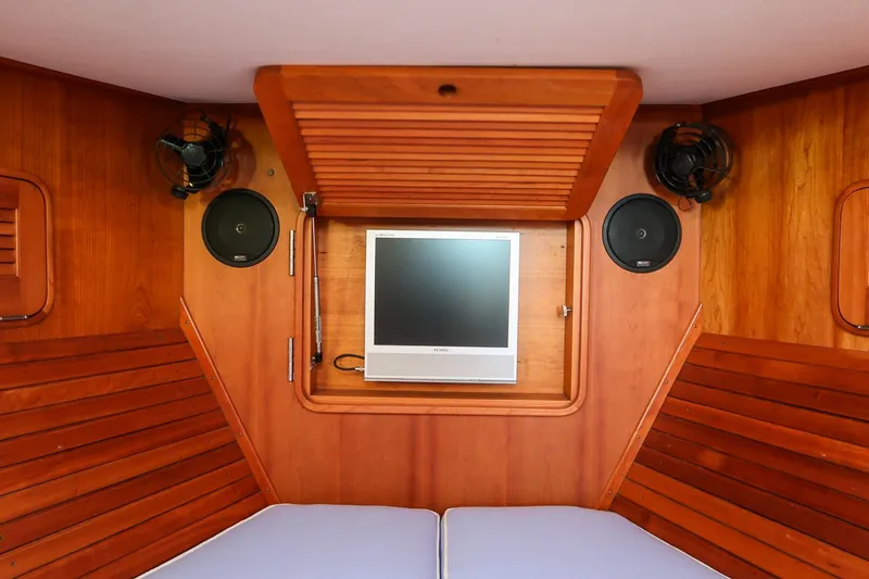 Slide: The Image of 2005 Hinckley Talaria 40 cabin interior with wooden paneling and blue bedding. - 30