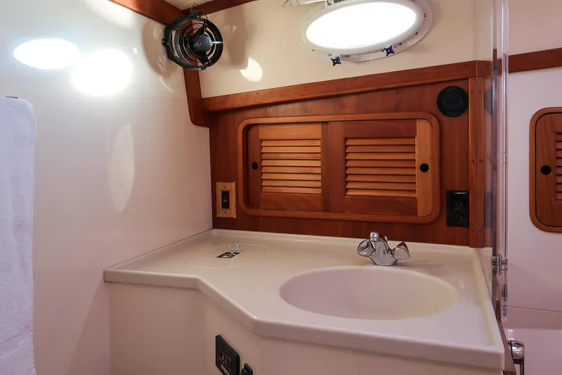 Slide: The Image of 2005 Hinckley Talaria 40 interior with wooden cabinetry and blue cushions. - 32