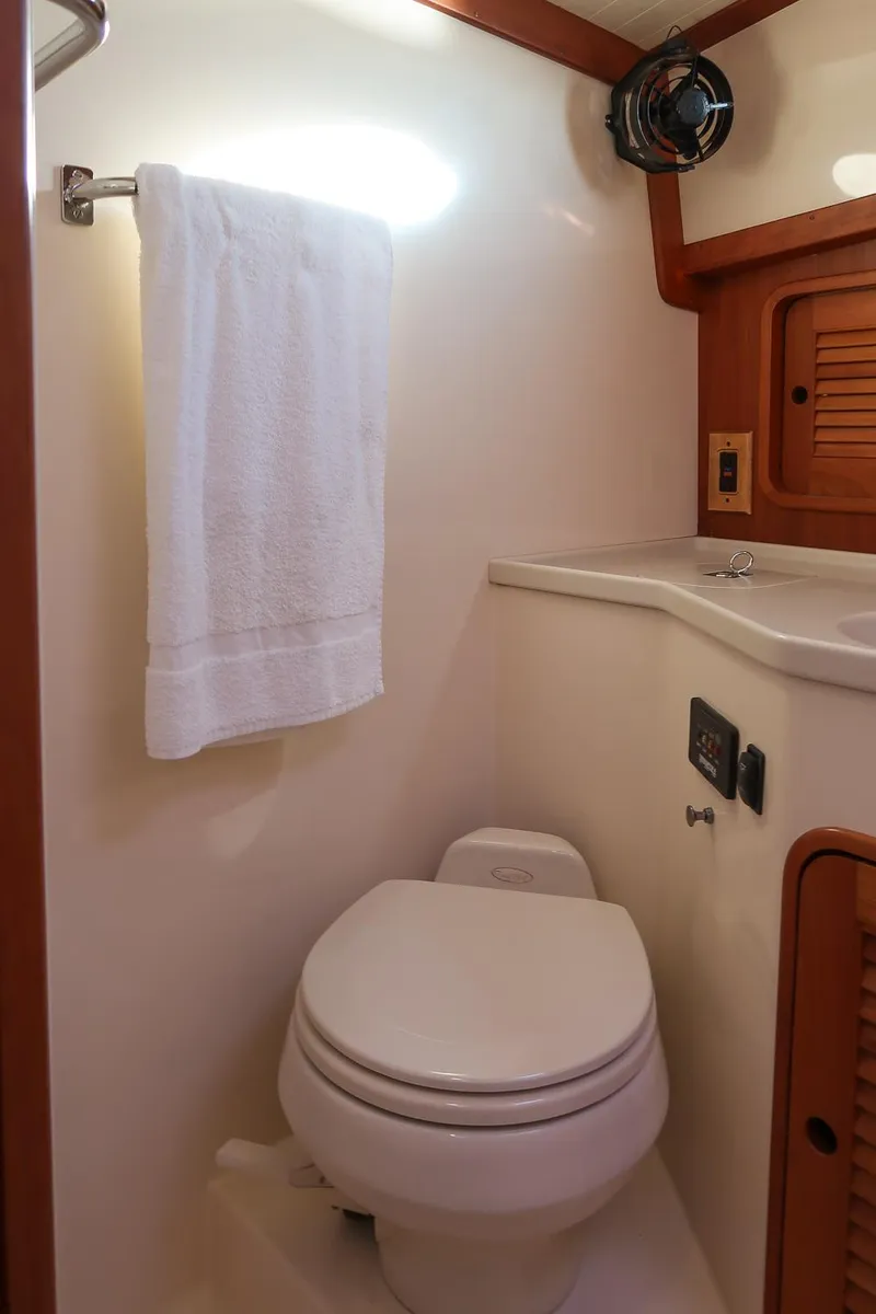 Slide: The Image of 2005 Hinckley Talaria 40 yacht bathroom with toilet, towel, and wooden accents. - 37