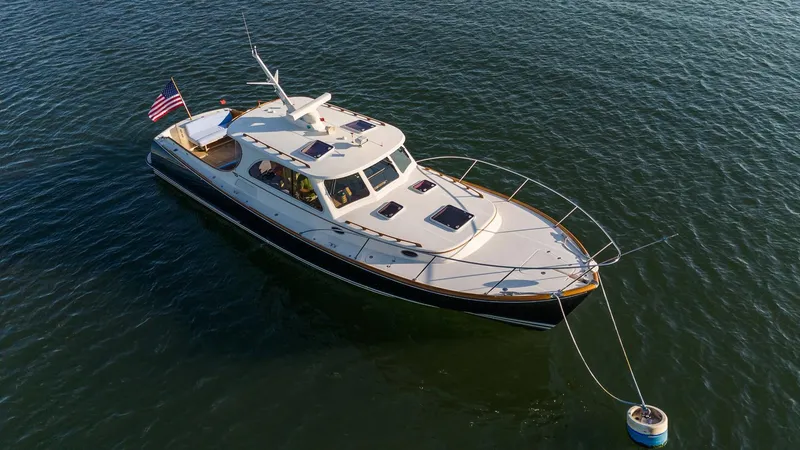 Slide: The Image of 2005 Hinckley Talaria 40 yacht anchored on calm water with American flag. - 45