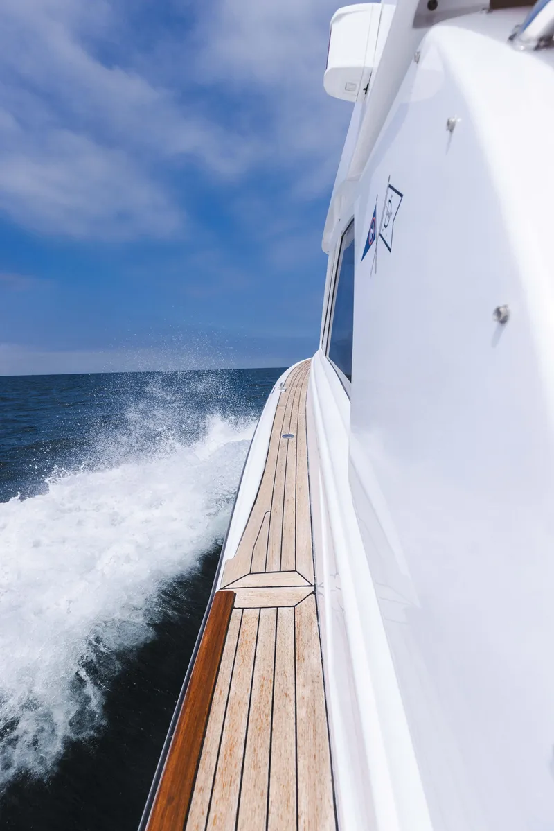 Slide: The Image of 2014 San Juan Open Express Cruiser on the water, side view. - 12