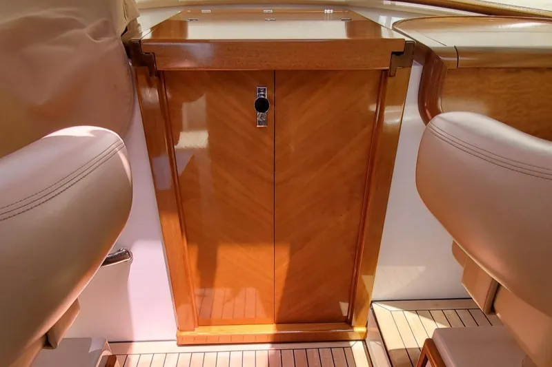 Slide: The Image of 2014 San Juan Open Express Cruiser interior with polished wood cabinetry and leather seating. - 17