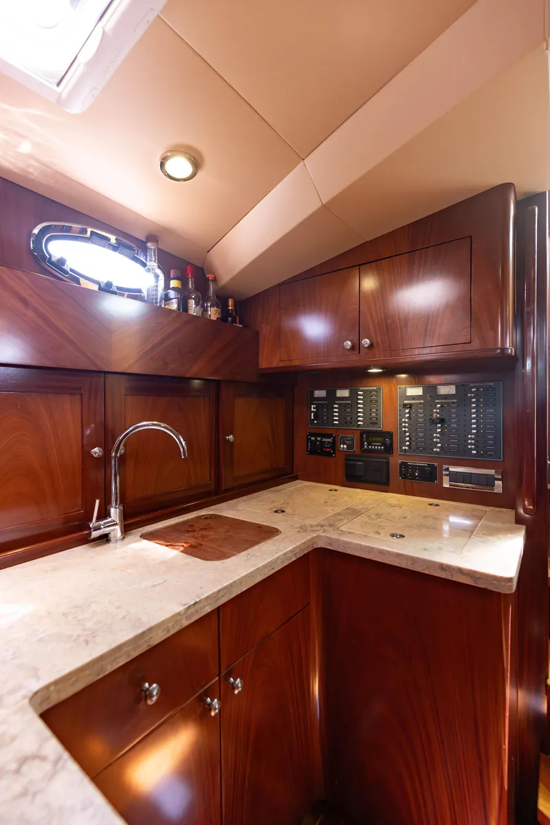 Slide: The Image of 2014 San Juan Open Express Cruiser kitchen with wood cabinetry and marble countertops. - 19