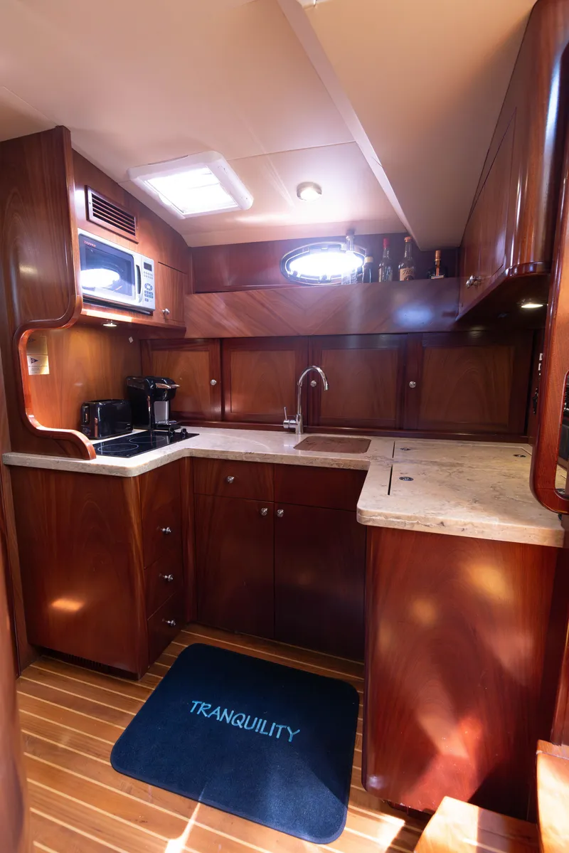 Slide: The Image of 2014 San Juan Open Express Cruiser kitchen with wooden cabinetry and modern appliances. - 20