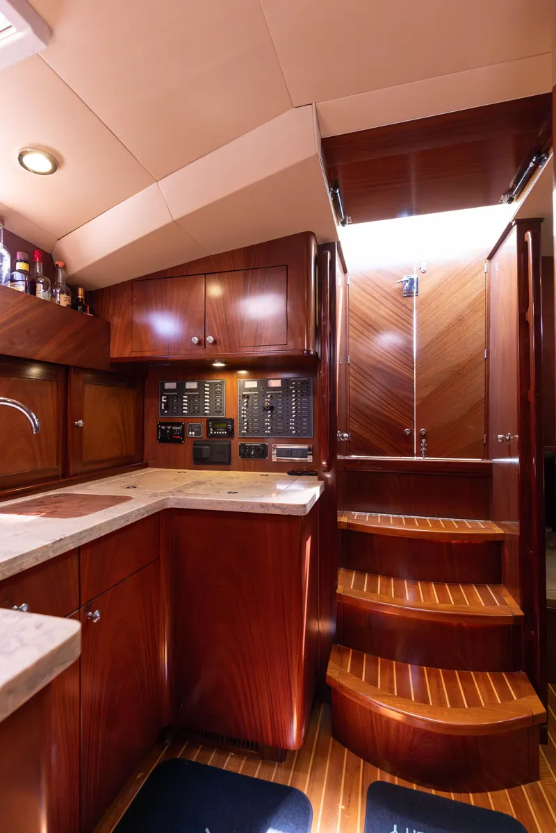 Slide: The Image of 2014 San Juan Open Express Cruiser interior with wooden cabinetry and stairs. - 21