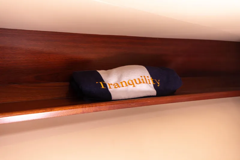 Slide: The Image of Folded towel labeled Tranquility on wooden shelf in 2014 San Juan Open Express Cruiser. - 29