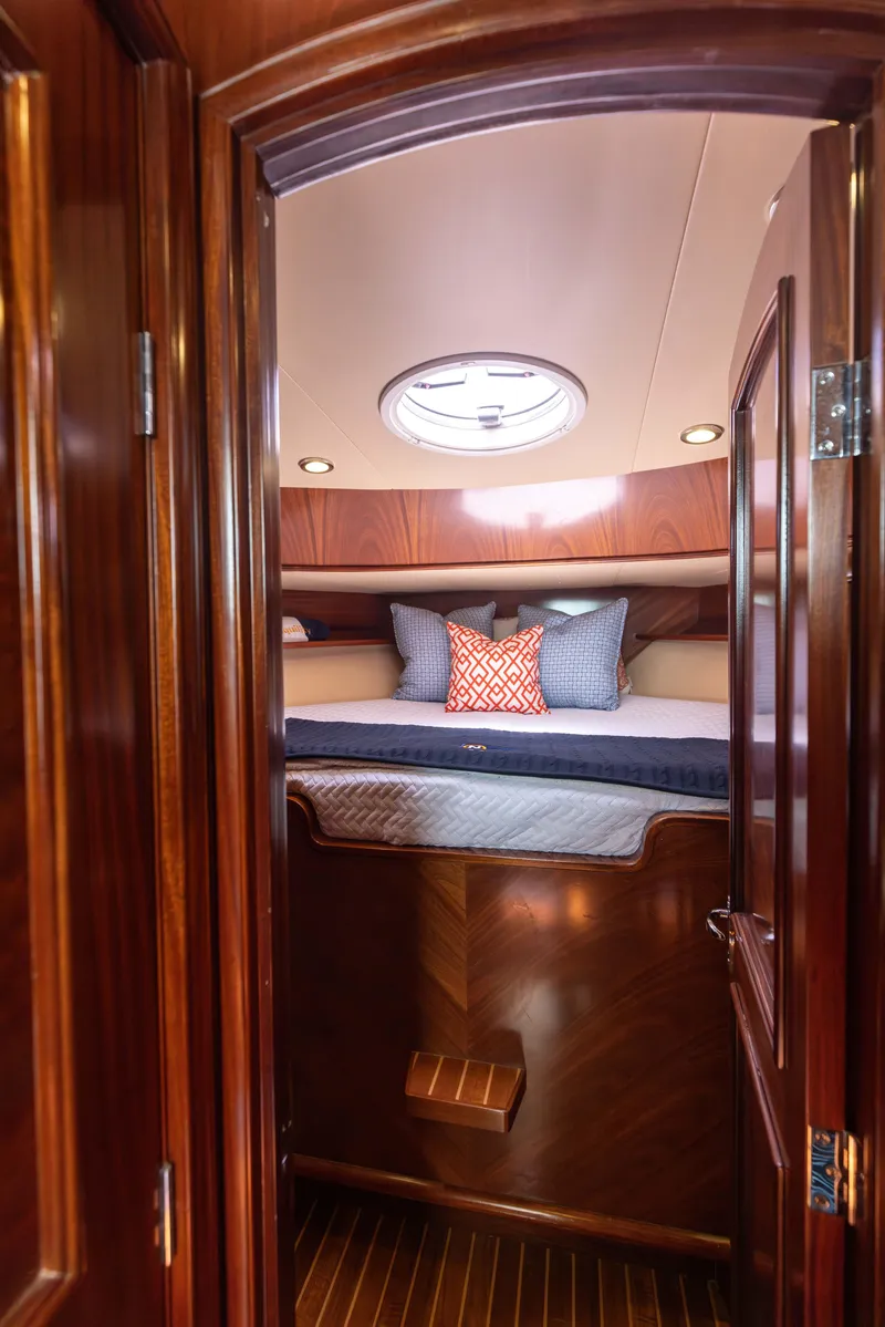 Slide: The Image of 2014 San Juan Open Express Cruiser cabin with luxurious wood finish and cozy bedding. - 31