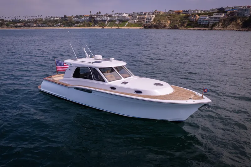 Slide: The Image of 2014 San Juan Open Express Cruiser on calm waters near a coastal town. - 35