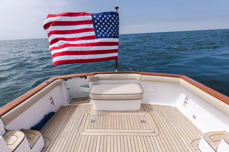 Slide: The Image of 2014 San Juan Open Express Cruiser with American flag on the ocean. - 42