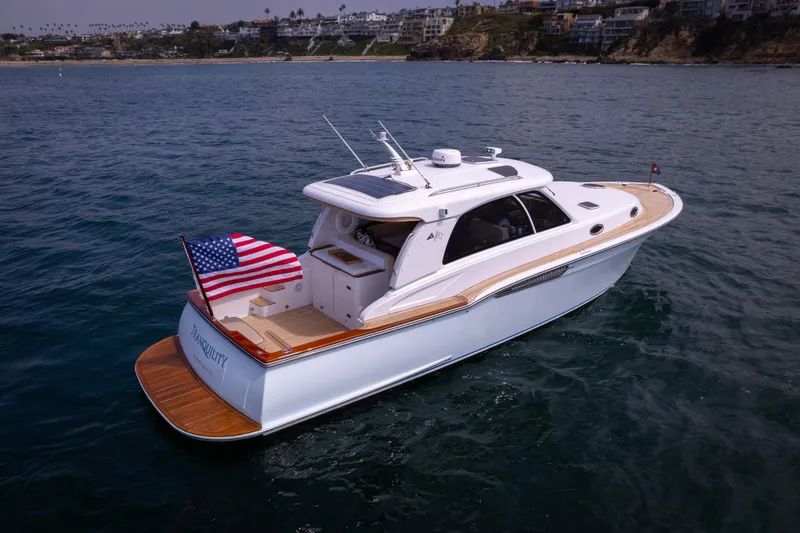 Slide: The Image of 2014 San Juan Open Express Cruiser on the water with American flag. - 43
