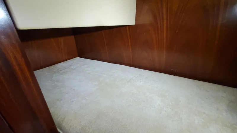 Slide: The Image of Interior cabin of 2014 San Juan Open Express Cruiser with wooden walls and cushioned bed. - 48