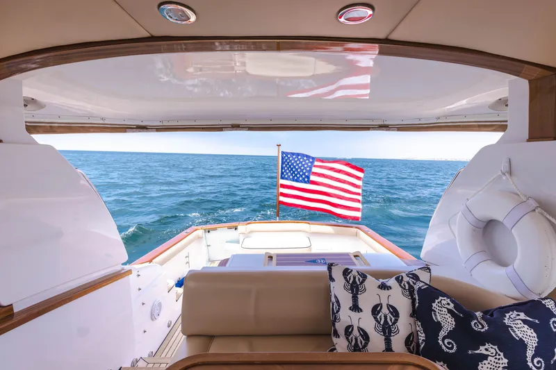 Slide: The Image of 2014 San Juan Open Express Cruiser with American flag on open sea. - 8