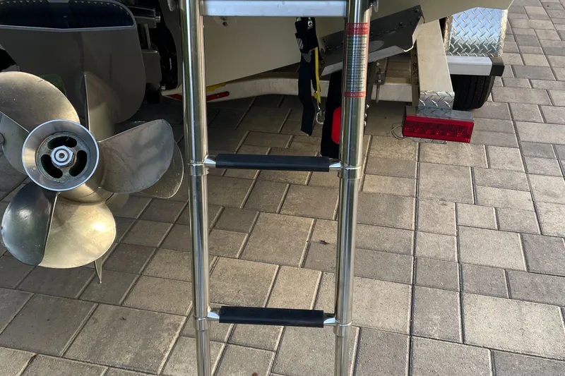 Slide: The Image of Chris-Craft Launch 25 GT 2022 boat ladder and propeller on paved surface. - 10