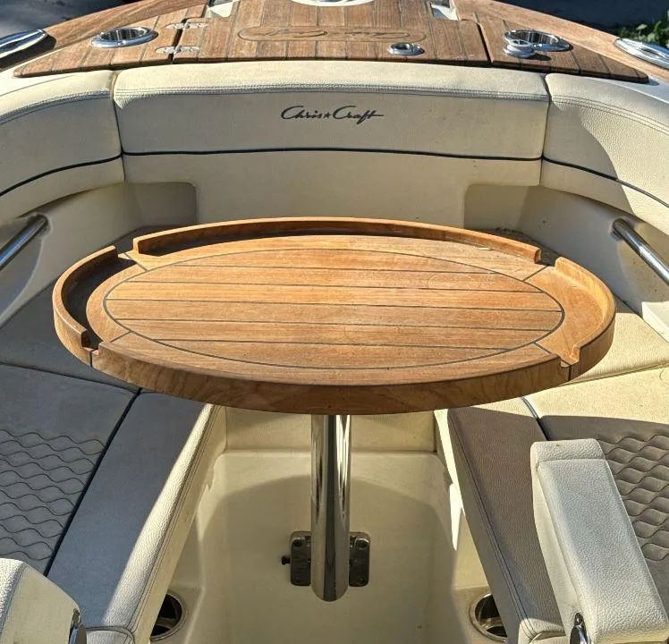 Slide: The Image of 2022 Chris-Craft Launch 25 GT interior with wooden table and cushioned seating. - 9