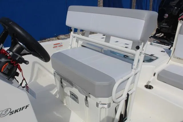 Slide: The Image of 2024 Mako Pro Skiff 19 CC boat stern with storage compartments and outboard motor. - 19