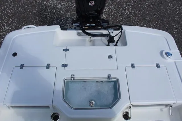 Slide: The Image of 2024 Mako Pro Skiff 19 CC boat with open storage compartments and seating. - 20