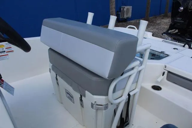 Slide: The Image of 2024 Mako Pro Skiff 19 CC boat interior with cushioned seating and storage. - 22