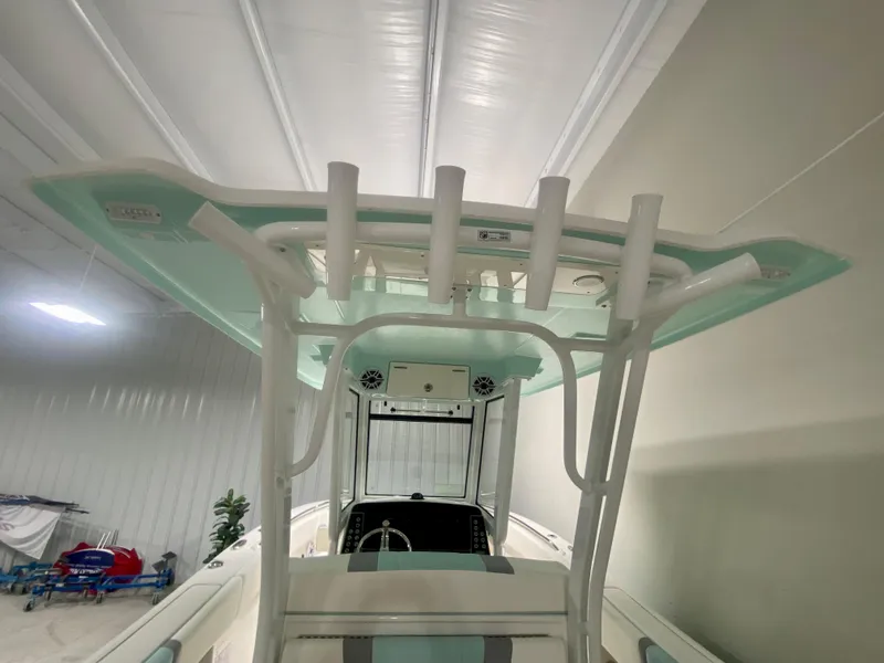 Slide: The Image of 2024 Robalo R270 boat interior with rod holders and T-top in a storage facility. - 16