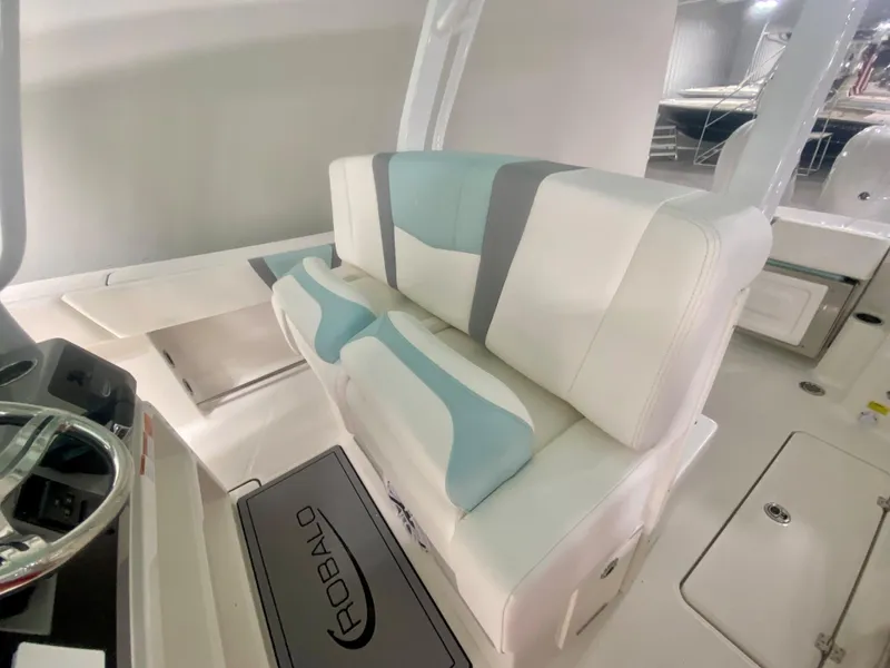 Slide: The Image of 2024 Robalo R270 boat interior with cushioned seating and steering console. - 17