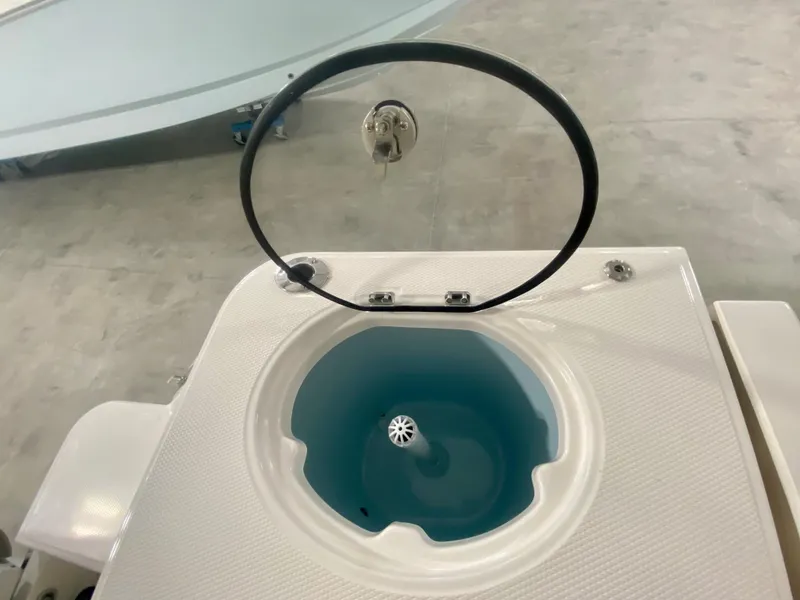 Slide: The Image of 2024 Robalo R270 livewell with open lid and blue interior. - 24