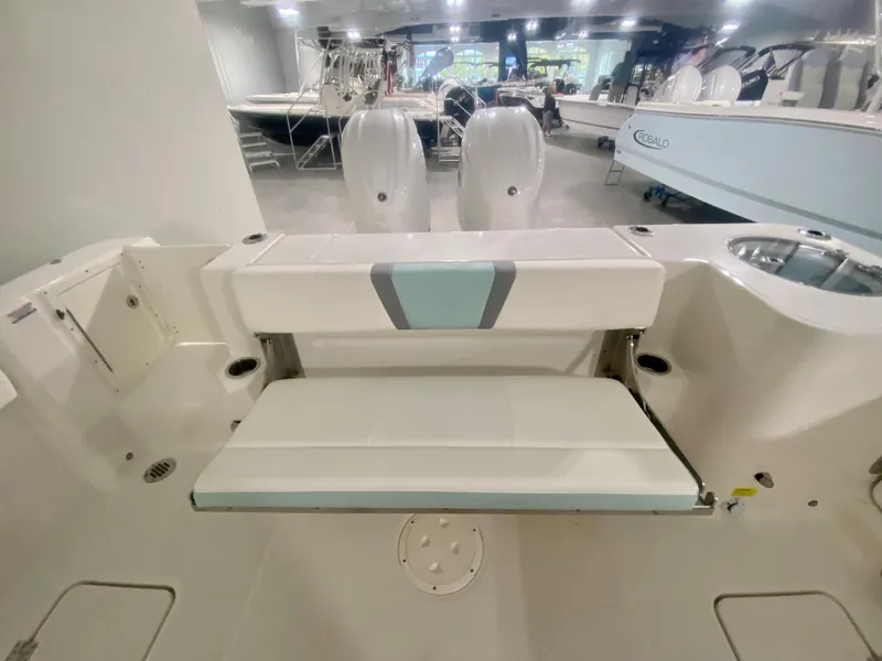 Slide: The Image of 2024 Robalo R270 boat interior with dual outboard motors in showroom. - 10