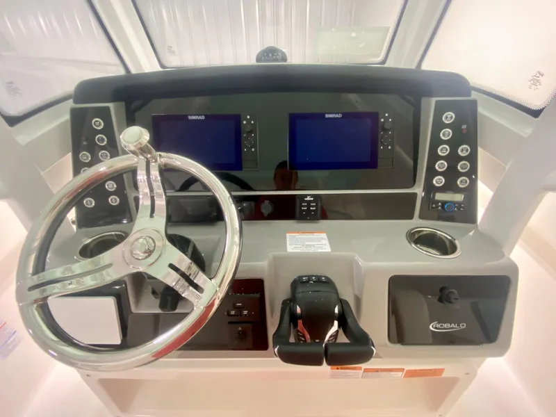 Slide: The Image of 2024 Robalo R270 boat dashboard with dual screens and steering wheel. - 19