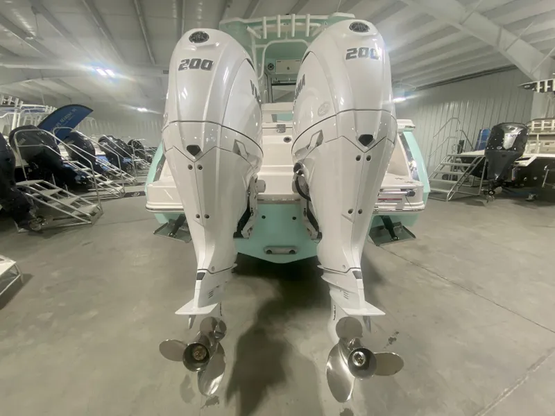 Slide: The Image of 2024 Robalo R270 boat with twin 200 horsepower outboard engines in a showroom. - 2