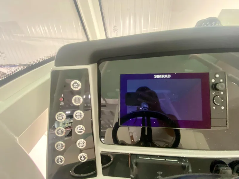 Slide: The Image of 2024 Robalo R270 boat dashboard with Simrad display and control panel. - 22