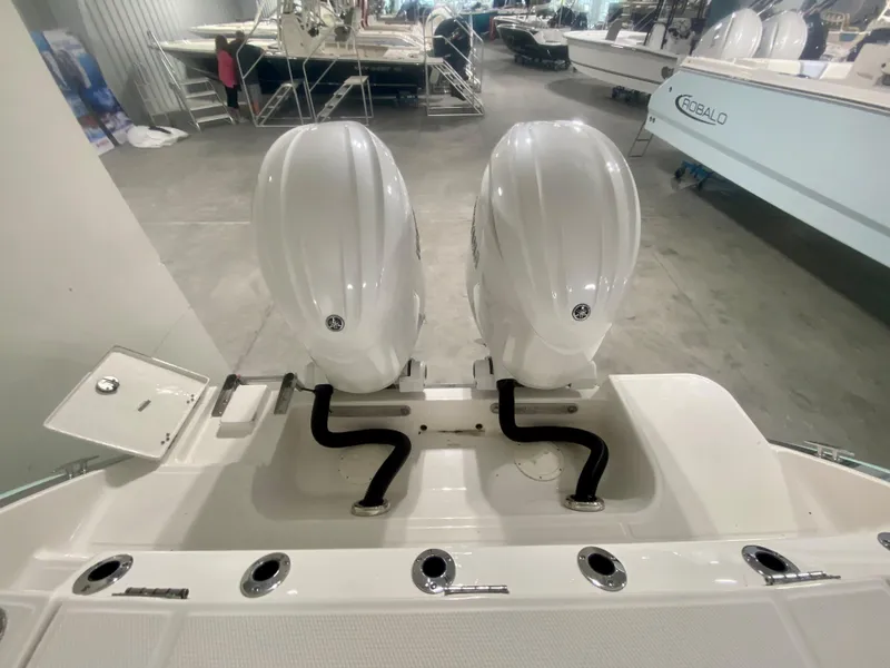 Slide: The Image of 2024 Robalo R270 boat with dual outboard engines in showroom. - 5