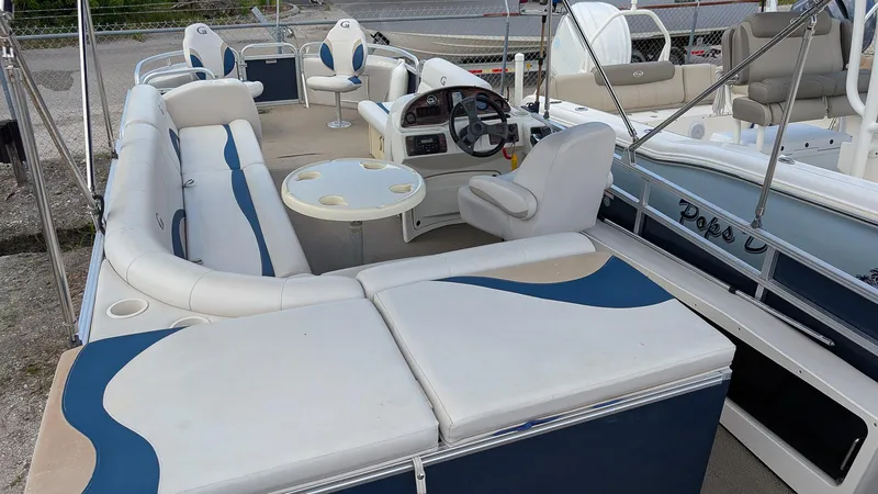 Slide: The Image of 2016 Avalon 2480 QF pontoon boat interior with seating and steering console. - 10