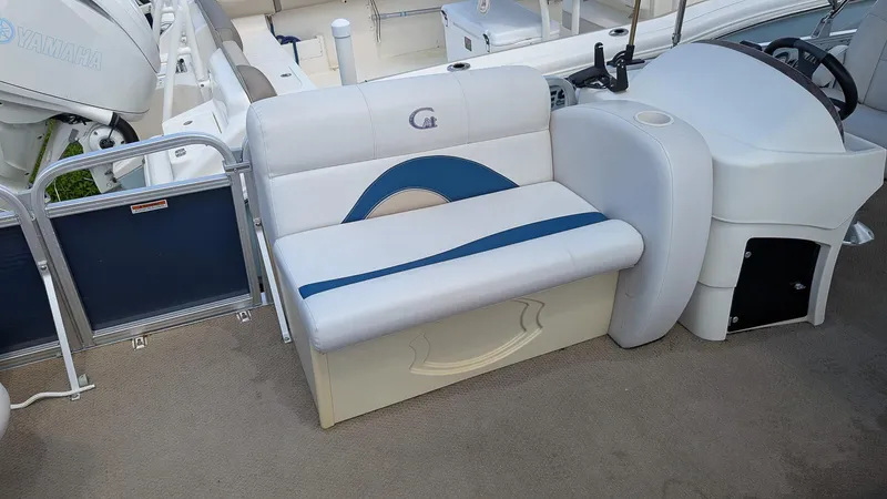 Slide: The Image of 2016 Avalon 2480 QF boat interior with white and blue seating and Yamaha engine. - 14