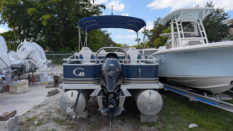 Slide: The Image of 2016 Avalon 2480 QF pontoon boat with Yamaha outboard motor, parked beside another boat. - 4