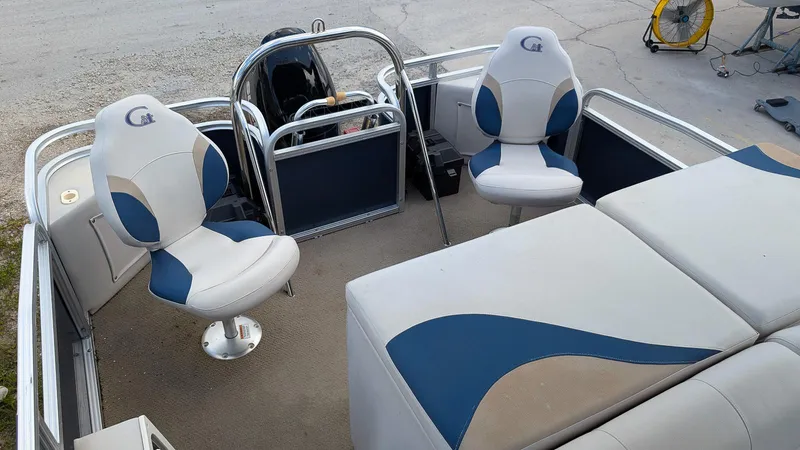Slide: The Image of 2016 Avalon 2480 QF pontoon boat interior with blue and beige seating. - 9