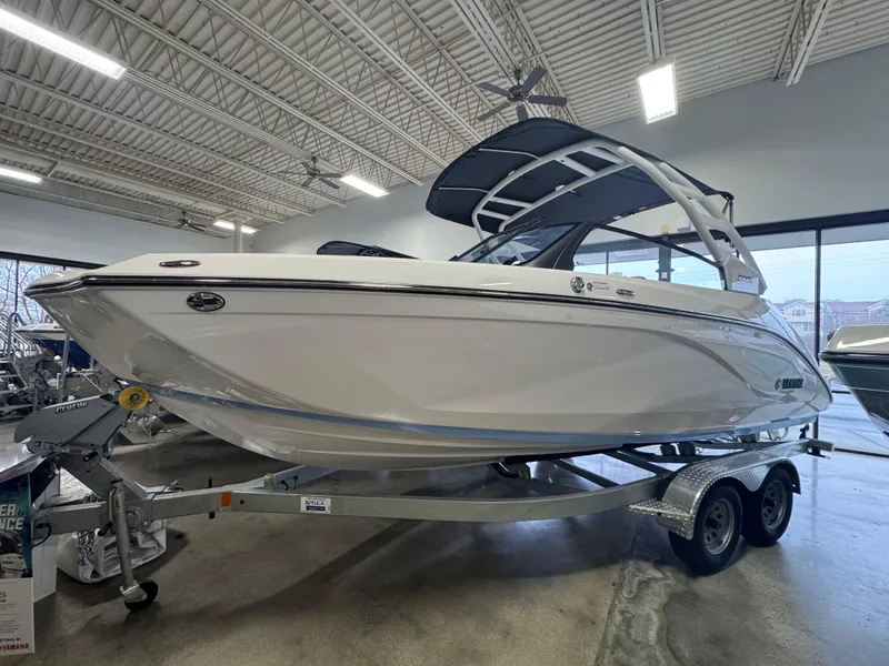 Slide: The Image of 2024 Yamaha Boats 222S on trailer in showroom, sleek white design. - 0