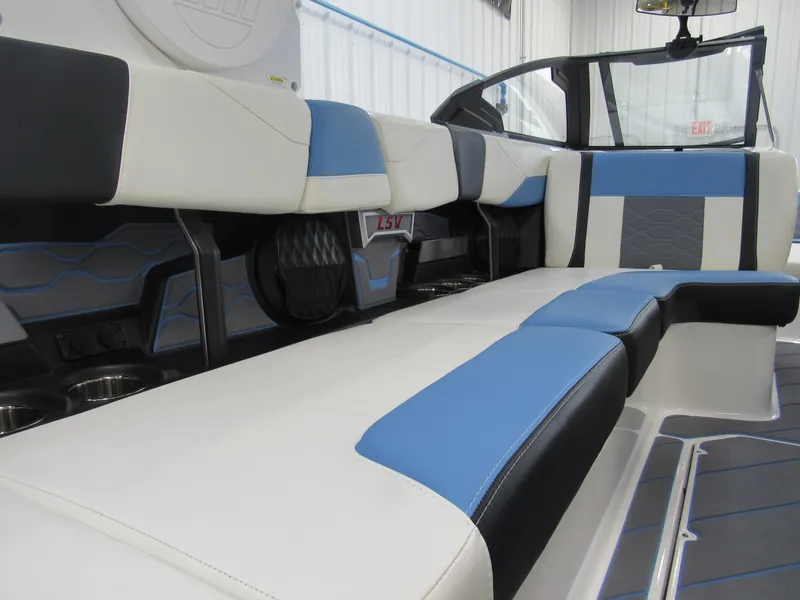 Slide: The Image of 2024 Malibu 23 LSV boat interior with blue and white seating. - 15