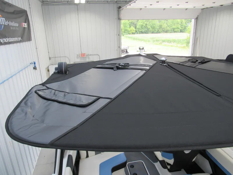Slide: The Image of 2024 Malibu 23 LSV boat with black cover in a garage setting. - 19