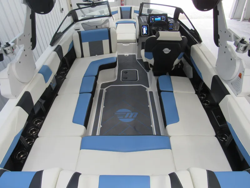 Slide: The Image of 2024 Malibu 23 LSV boat interior with blue and white seating, modern dashboard. - 5